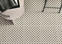 Beige geo porcelain tile on the floor with table and chair legs in view.