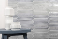 Sfumature crayon ehex picket wall tile in Azzurro installed behind a modern table and decorative vase.